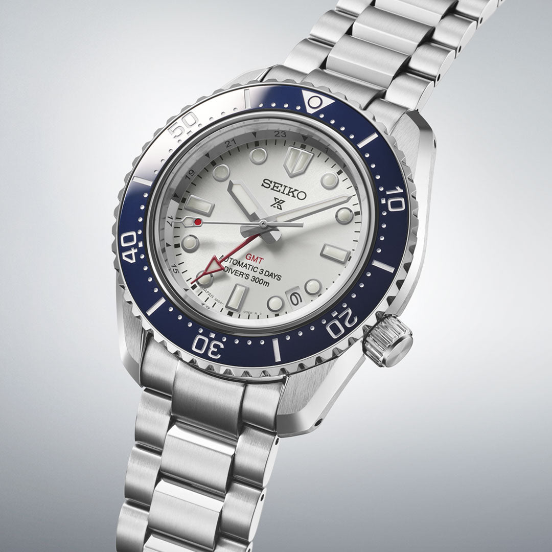 The Seiko Prospex Sea 1965 Diver's GMT Automatic 42mm features a stainless steel case, silver dial, blue ceramic bezel, and red GMT hand. Its angled display highlights the bracelet, crown, and markers for a robust yet elegant look.