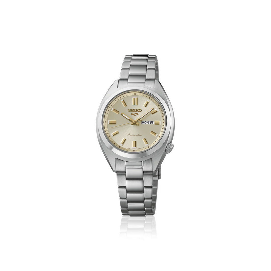 The Seiko 5 Sports SNXS Series Automatic 32mm Watch by Seiko features a stainless steel silver strap, a beige dial, gold hour markers, and a convenient day-date display on the right side.
