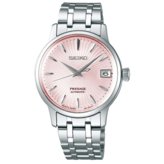 The Seiko Presage Cocktail Time Automatic With Manual Winding 33.8mm Watch features a silver metal band, light pink textured dial, silver hour markers and hands, plus a date window at 3 o’clock.