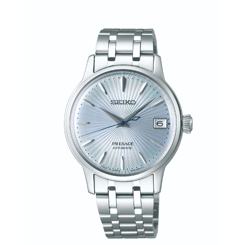 The Seiko Presage Cocktail Time Automatic 33.8mm Watch, crafted by Seiko, features a stainless steel construction with a silver automatic movement. Its textured light-blue dial is embellished with silver hour markers and hands, complemented by a date display at the 3 o'clock position. Enhancing its sophisticated design is a robust stainless steel bracelet and round case.