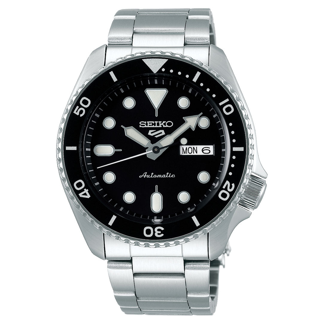 The Seiko 5 Sports SKX Series Automatic 42.5mm watch features a black dial, bold white hour markers, silver hands, stainless steel band, day-date display, and a rotating dive bezel.