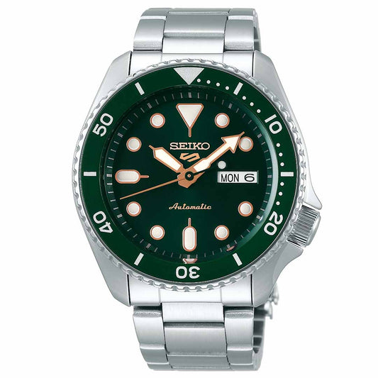 A Seiko 5 Sports SKX Series automatic wristwatch with a green dial, offering time, date, and day display against luminescent hour markers and hands. The silver watch boasts minute markers on its bezel and features an automatic movement paired with a stainless steel band for a stylish look.