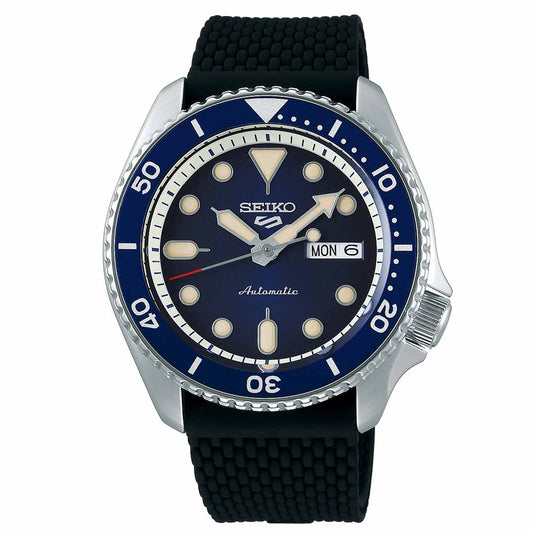 Explore the Seiko 5 Sports Automatic 42.5mm Watch from Seiko, showcasing a captivating blue dial and bezel paired with a sleek black rubber strap and luminous markers. This timepiece combines elegance with practicality, featuring water resistance and a day-date display at the 3 o'clock position.