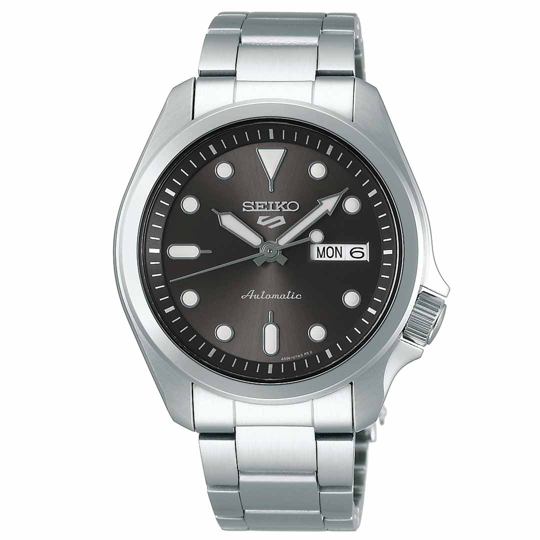 A silver stainless steel wristwatch from the Seiko 5 Sports SKX Series, featuring a black dial with luminous markers and the Seiko name prominently displayed. The watch includes day and date windows on the right side and an "Automatic" label above the 6 o'clock position, complemented by a polished metal bracelet for a refined finish.