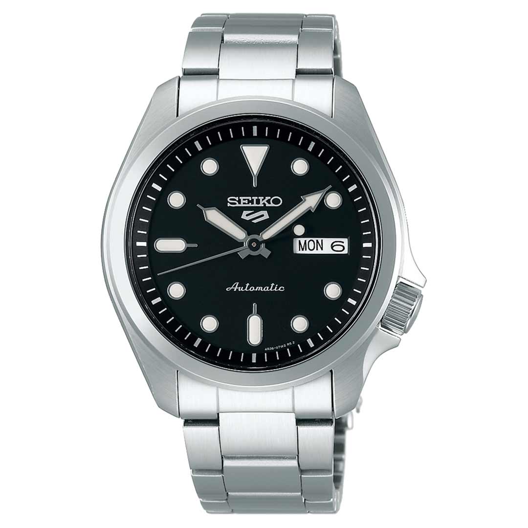 The Seiko 5 Sports SKX Series Automatic 42.5mm Watch features a black dial and a stainless steel band. This stylish model displays the day and date on the right side of the face, complemented by luminous hands, blending a sporty yet elegant design with white hour markers.