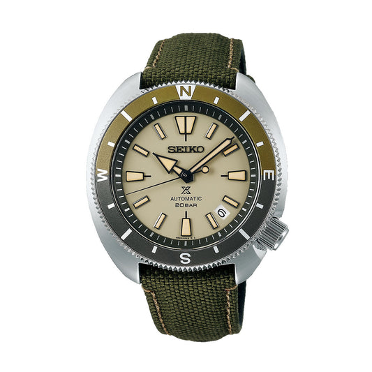 The Seiko Prospex Land Automatic with Manual Winding 42.4mm Watch features a round beige dial and a striking black and green bezel marked with compass directions. Designed as a diver's watch, it includes silver hour markers and a robust green canvas strap, with "20 BAR" prominently displayed on the dial.