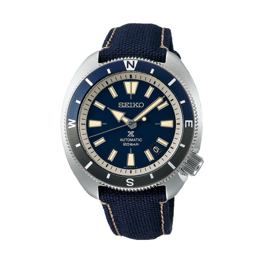 The Seiko Prospex Land Automatic With Manual Winding 42.4mm Watch by Seiko features a navy blue face and band, accented with a silver bezel adorned with compass markings and distinctive hour markers. As a diver's watch, its water resistance adds to its functionality while maintaining its stylish appearance.