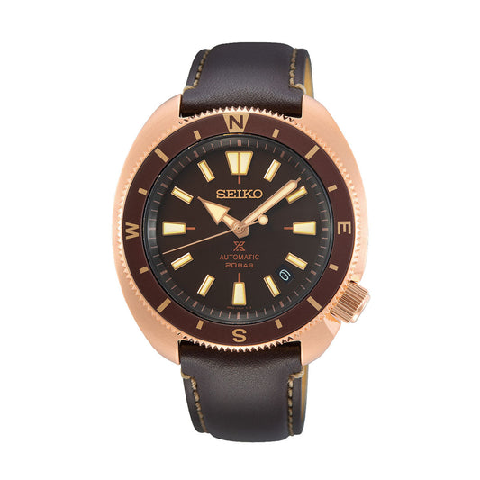 The Seiko Prospex Land Automatic With Manual Winding 42.4mm Watch by Seiko features a brown leather strap and a rose gold-tone bezel. Ideal for adventure seekers, the watch boasts a black dial with luminous indices, gold-tone hands, day-date display, and compass markings on the bezel.