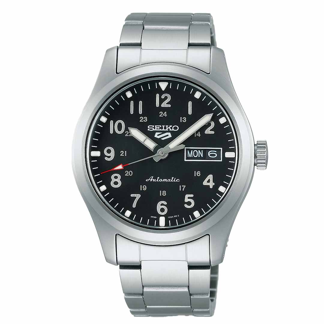 The Seiko 5 Sports Field Series Automatic 39.3mm Watch from Seiko showcases a black dial with both 12 and 24-hour displays, an automatic movement, and a day-date window indicating Monday the 6th. The watch also features a red-tipped second hand, accompanied by a silver case and a linked stainless steel bracelet.