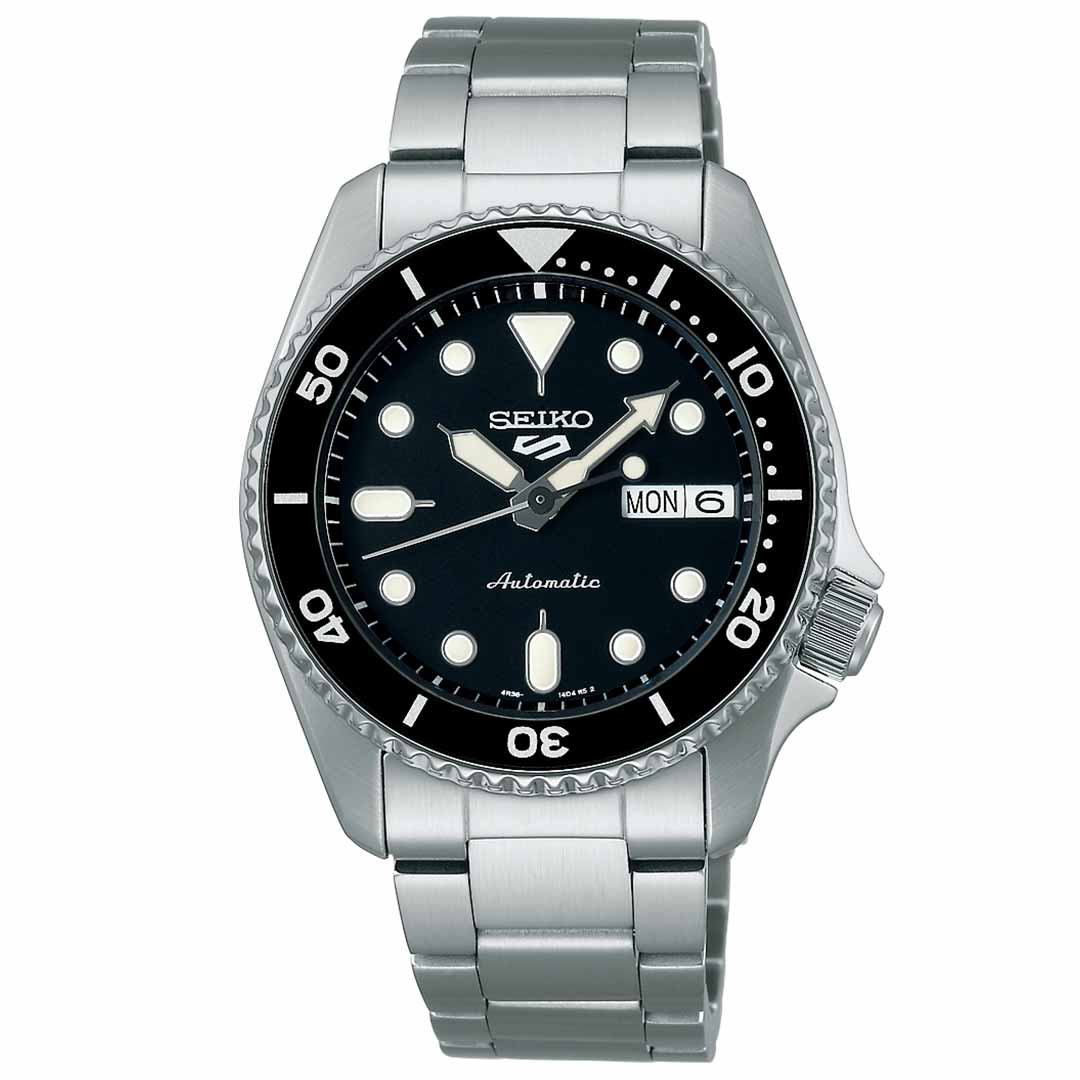 The Seiko 5 Sports SKX Series Automatic 38mm Watch features a black dial with large luminous hour markers and hands. Its stainless steel bracelet pairs well with the rotating bezel that includes minute markers, while the day and date display on the right side enhances functionality. The Seiko brand name is prominently displayed at the top.