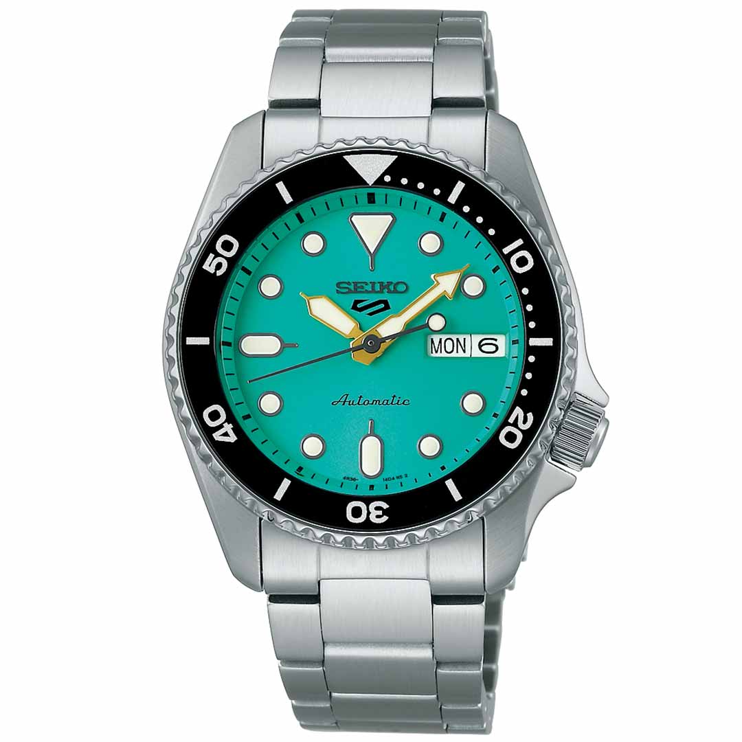 The Seiko 5 Sports SKX Series Automatic 38mm Watch from Seiko features a stunning teal face with luminescent hour markers and a day-date display. It includes automatic movement, complemented by a black rotating bezel with numbered markings and is finished with a stainless steel bracelet. The watch's hands are silver, enhanced with luminescent detailing.