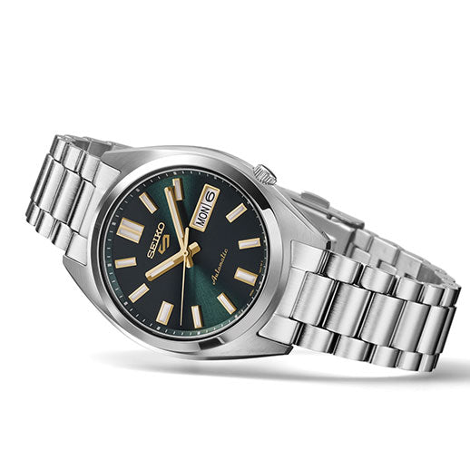 The Seiko 5 Sports SNXS Series Automatic 37.4mm Watch features a stainless steel band, green dial, gold-tone hour markers and hands, and a day-date display at 3 o’clock.