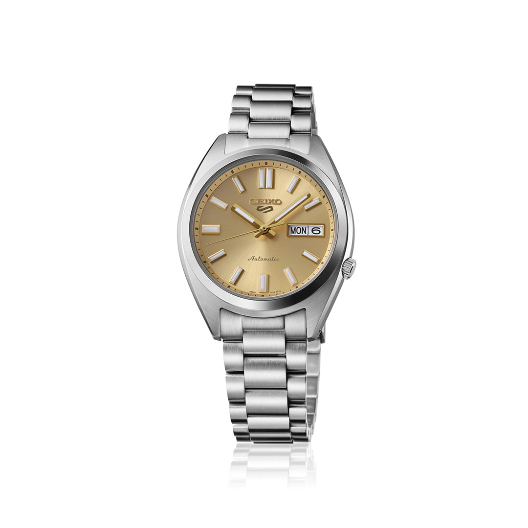 A Seiko 5 Sports SNXS Series Automatic 37.4mm watch by Seiko, featuring a stainless steel silver case and metallic band, complemented by a gold dial with day and date display. The watch showcases silver hour markers and hands, all presented against a plain white background.