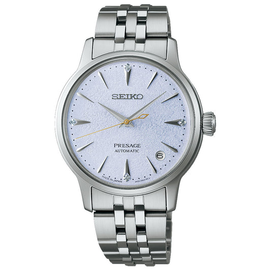 The Seiko Presage Cocktail Time Automatic 34mm watch features a textured light blue dial, silver markers, gold second hand, date at 3 o’clock, and a metal link bracelet.