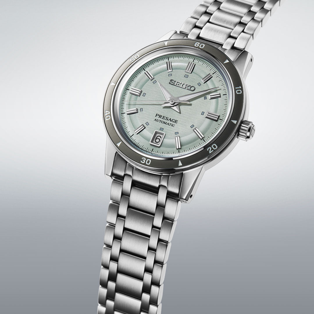 The Seiko Presage Style 60's Automatic with Manual Winding 39.5mm Watch features a mint green textured dial, date window at 6 o'clock, and stainless steel bracelet, shown against a gradient grey background.
