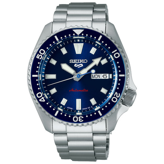 The Seiko 5 Sports SKX Series Automatic 42.5mm Watch features a blue sunray dial, white hour markers, silver hands, day-date display at 3 o’clock, rotating bezel, and a brushed stainless steel bracelet.