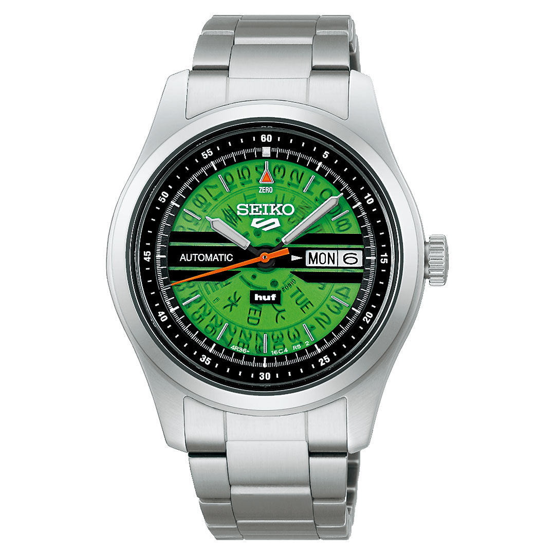 The Seiko 5 Field Series Automatic with Manual Winding 39.4mm Watch HUF Limited Edition (7,000 pieces) features a silver band, green dial with black/yellow day/date markers, silver hour markers, and a black minute outer ring.