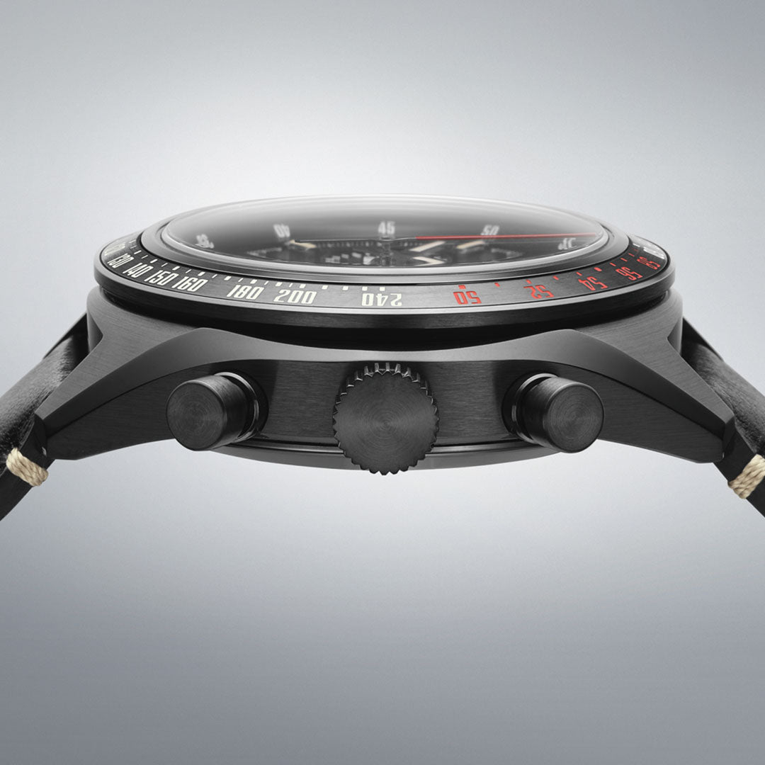Side view of the Seiko Prospex Speedtimer Datsun 240Z Chronograph Automatic 42mm Limited Edition watch, black case with two buttons and crown, black bezel with white/red markings, and a black leather strap with beige stitching.