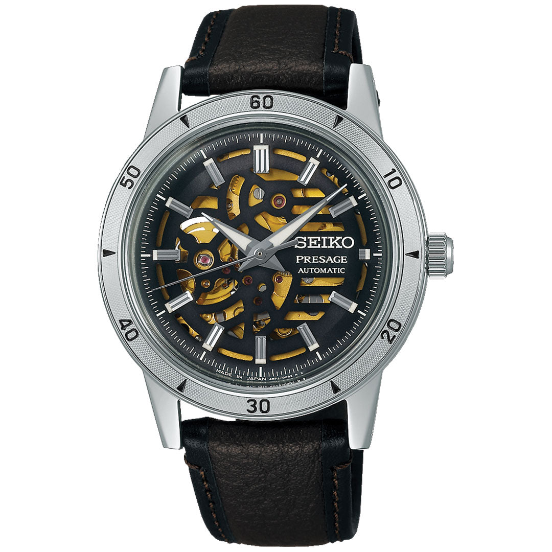 The Seiko Presage Style 60's Automatic with Manual Winding 39.5mm Watch features a silver case, skeleton dial showing gold gears, a black outer ring with minute markers, and a black leather strap with brown stitching.