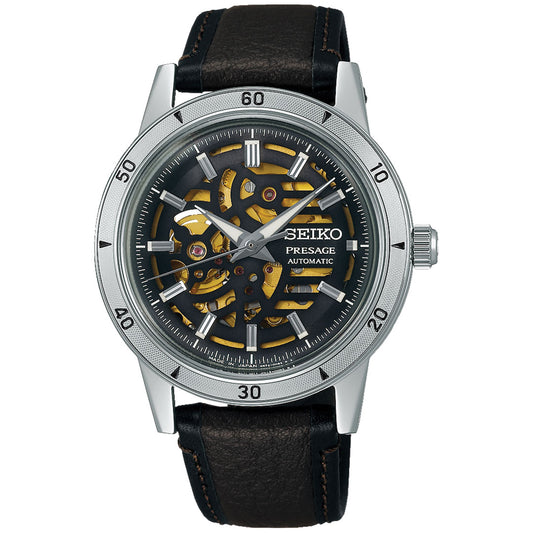 The Seiko Presage Style 60's Automatic with Manual Winding 39.5mm Watch features a silver case, skeleton dial showing gold gears, a black outer ring with minute markers, and a black leather strap with brown stitching.