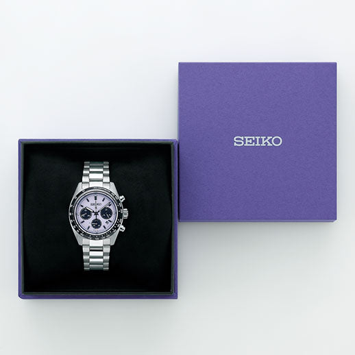 The Seiko Prospex Speedtimer Solar Chronograph 39mm Tokyo 25 Limited Edition watch is shown with a metal band and three subdials in an open purple Seiko box beside its matching lid, all set against a white background.