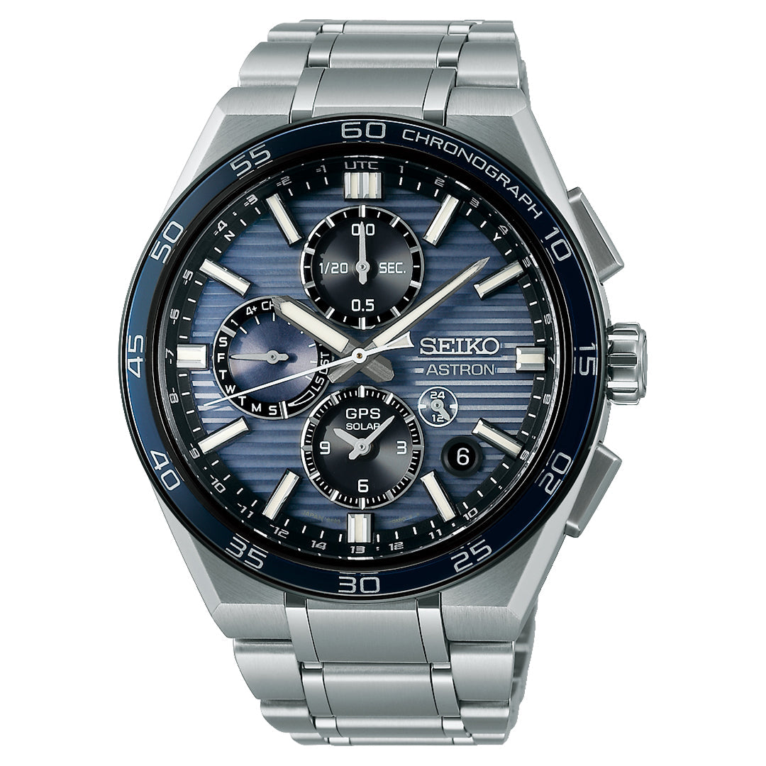 The Seiko Astron GPS Solar 44.1mm Watch features a stainless steel case, blue textured dial with three subdials, perpetual calendar, chronograph, silver hour markers, black bezel with white markings, and date at 4 o’clock.