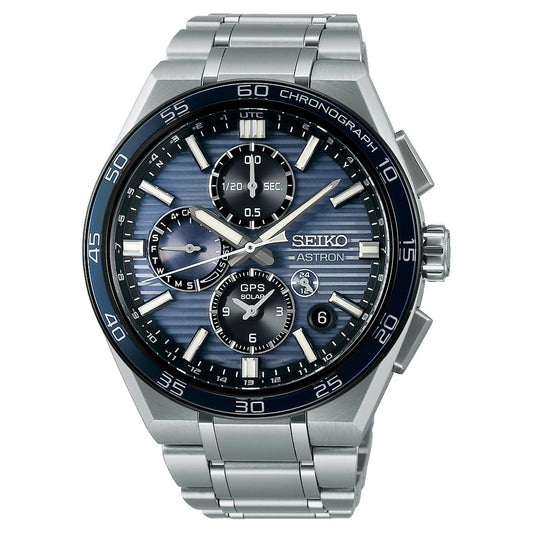 The Seiko Astron GPS Solar 44.1mm Watch features a stainless steel case, blue textured dial with three subdials, perpetual calendar, chronograph, silver hour markers, black bezel with white markings, and date at 4 o’clock.