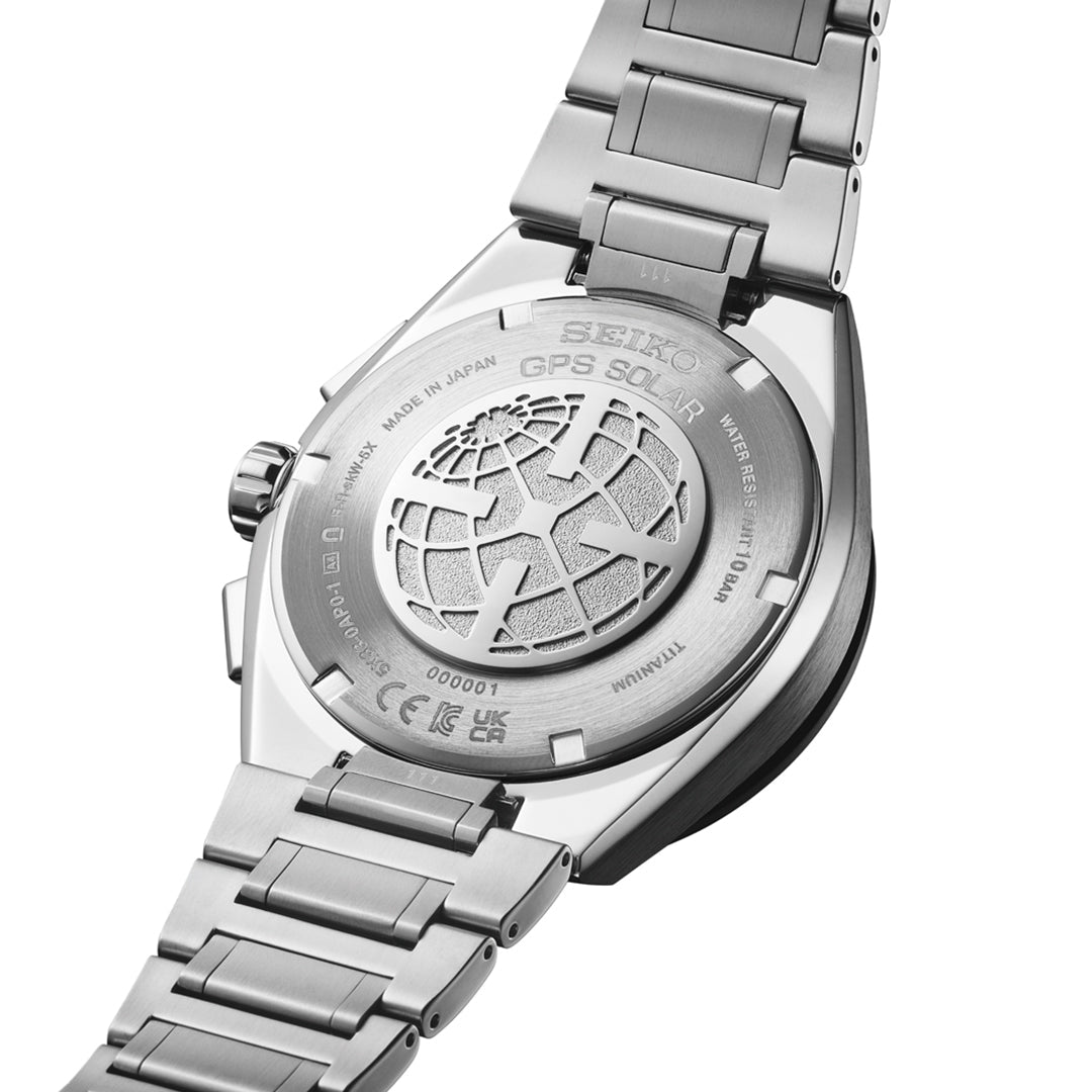 Close-up of the Seiko Astron GPS Solar 44.1mm Watch’s back, showing its metal bracelet, engraved globe design, various inscriptions, and titanium mark—all highlighting Seiko’s advanced GPS signal reception technology.