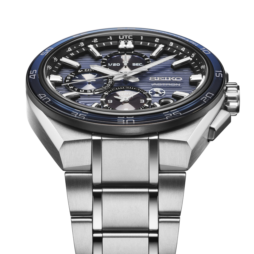 A close-up of the Seiko Astron GPS Solar 44.1mm Watch by Seiko, showcasing its stainless steel case, blue and black multi-function dial with perpetual calendar, silver markers, and metal bracelet from an angled perspective.