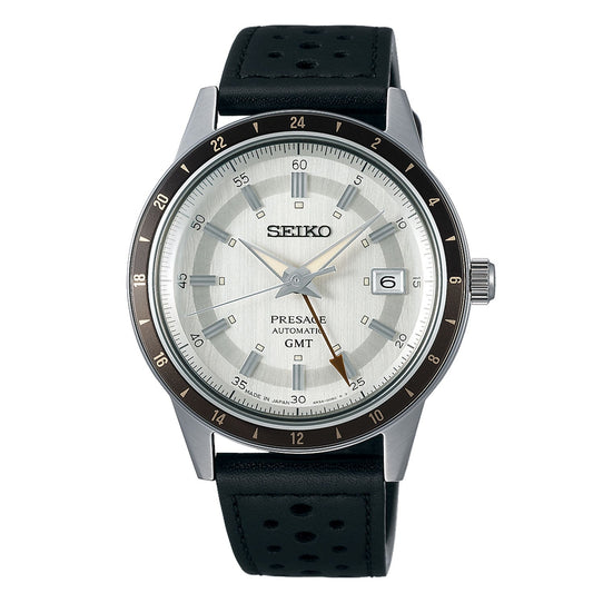 The Seiko Presage Style 60's Automatic With Manual Winding 40.8mm Watch features a silver dial and a black perforated leather strap, complemented by a date display at 3 o'clock. Its elegant minimalist design includes a 24-hour clock, and it is driven by automatic movement for precision and reliability.