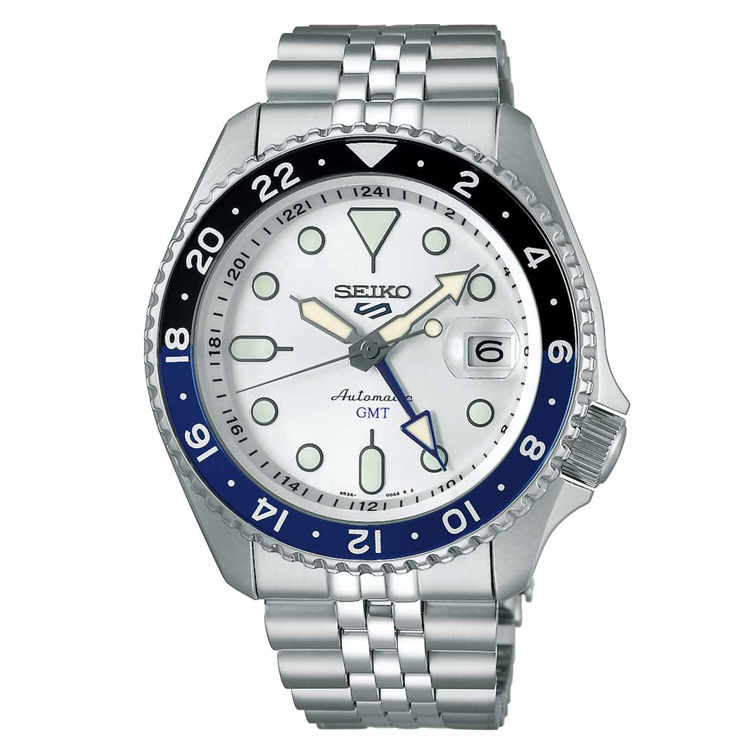 The Seiko 5 Sports SKX Series Automatic 42.5mm Watch by Seiko showcases a stainless steel bracelet and a silver-tone case, complemented by a white dial and a unique black-and-blue 24-hour rotating bezel. The inclusion of black hour markers and hands, along with a blue GMT hand, provides excellent readability.