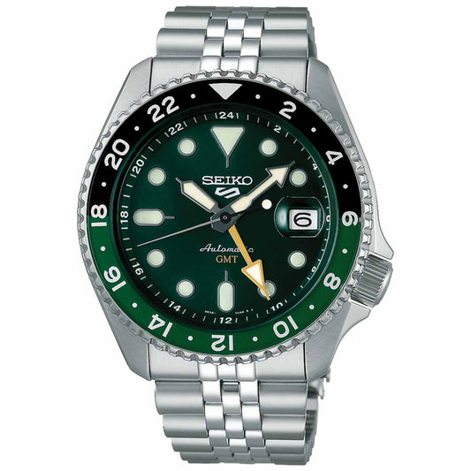 Introducing the Seiko 5 SKX Series Automatic 42.5mm Watch, an elegant timepiece featuring a rich green dial and bezel with crisp white hour markers. This watch offers GMT functionality with 24-hour markings and a date window at the 3 o'clock position, all complemented by a sleek silver metal bracelet.