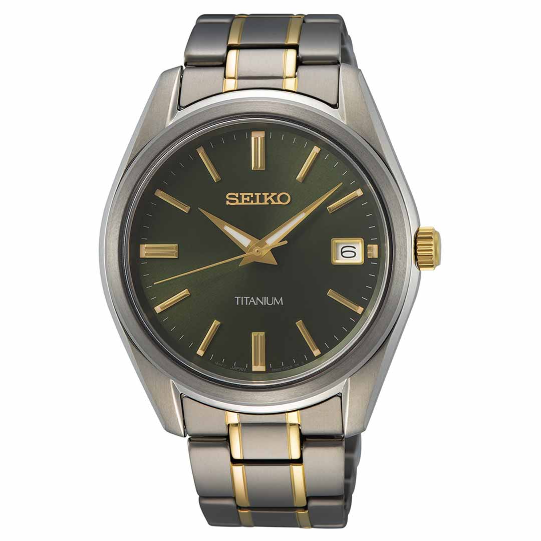 The Seiko Essentials Quartz 40.2mm Watch, crafted by Seiko, is a titanium timepiece featuring a green dial adorned with gold-tone hour markers and hands. It includes quartz movement and a date display at the 3 o'clock position. The watch's metal bracelet elegantly blends silver and gold-tone links.