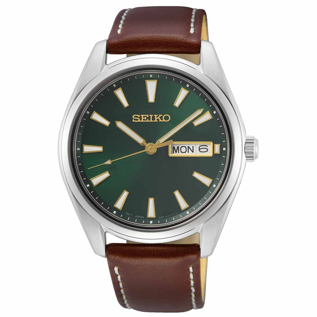 The Seiko Essentials Quartz 40.2mm Watch by Seiko features a striking green dial housed in a silver stainless steel case and complemented by a brown leather strap. It is designed with gold hour markers and hands, while the day-date window at the 3 o'clock position displays "MON 6.