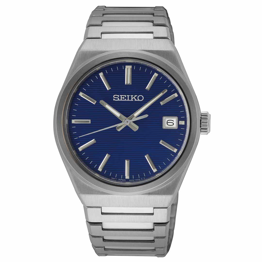 The Seiko Essentials Quartz 39mm Watch features a stainless steel band and an eye-catching blue dial. It is complemented by silver hour markers, sleek hands, and a date display at the 3 o'clock position, adding elegance to this classic timepiece.