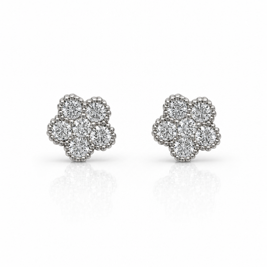 The Roberto Coin Tennis Flower 18K White Gold Diamond Stud Earrings feature six round diamonds in each floral-shaped earring, set in white gold with a beaded border, displayed on a white background with a subtle reflection.