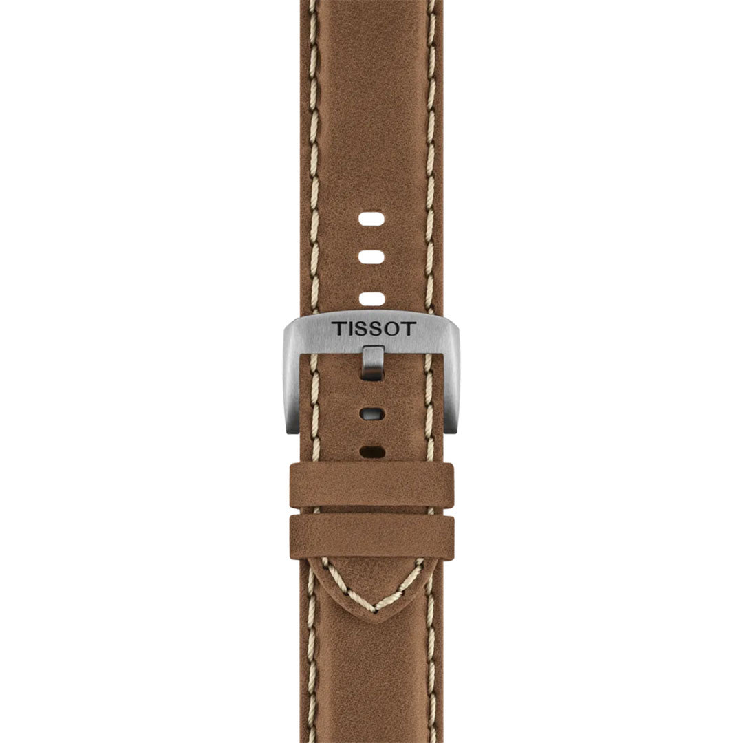 Close-up of a brown leather strap with beige stitching and a silver buckle engraved "TISSOT," designed for the Tissot CHRONO L Quartz 42mm Watch by Tissot, neatly threaded through two loops.
