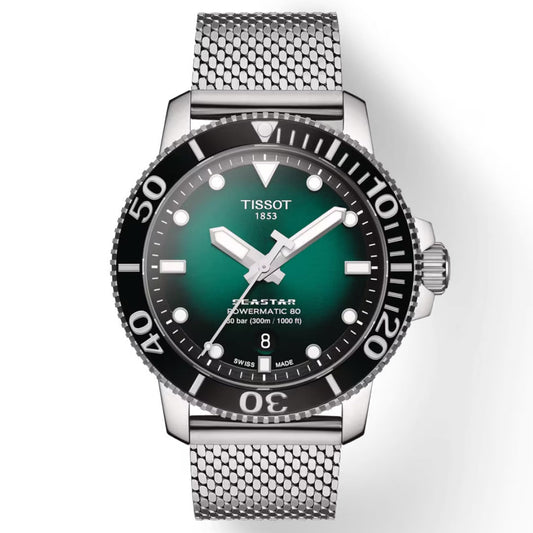 The Tissot Seastar 1000 Powermatic 80 Automatic 43mm Watch is a sophisticated water sports timepiece featuring a striking green gradient dial and black bezel. It is powered by Swiss-made automatic movement and showcases bold white hour markers, luminescent hands, and a date display at the 6 o'clock position. The stainless steel mesh strap complements its modern design.