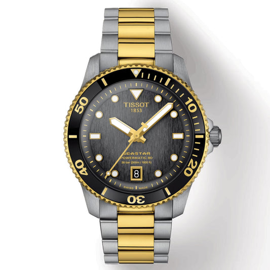 The Tissot Seastar 1000 Powermatic 80 Automatic 40mm Watch from Tissot features a luxurious two-tone stainless steel and gold bracelet. It is enhanced by a black bezel with gold and white accents, includes a date display at the 6 o'clock position, and boasts Super-LumiNova detailing. Additionally, it is water-resistant for extra durability.