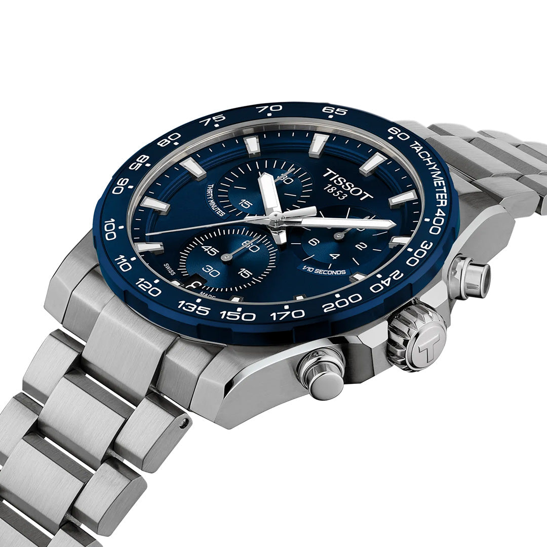 The Tissot Supersport Chrono Quartz 42mm Watch by Tissot is shown at an angle, featuring a silver stainless steel link bracelet, blue tachymeter bezel, blue dial with three subdials, and sophisticated quartz movement for precise timekeeping.