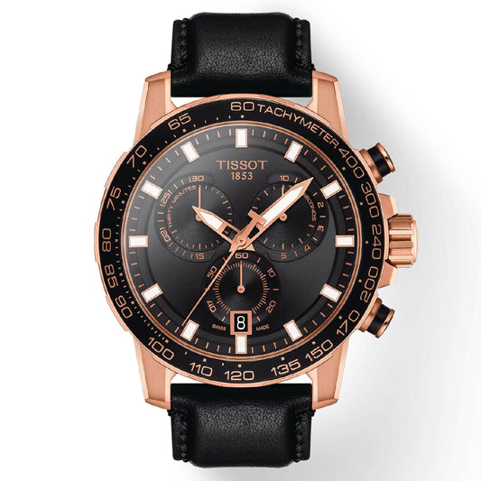 The Tissot Supersport Chrono Quartz 45.5mm Watch by Tissot features a black dial with rose gold accents, a tachymeter scale, three subdials, and a date window at 6 o'clock. It is powered by Swiss Quartz Movement and protected by sapphire crystal. The watch offers water resistance up to 100 meters and is finished with a rose gold casing and black leather strap.