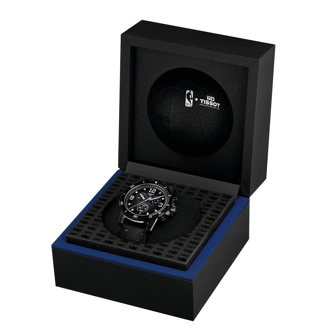 The Tissot Supersport NBA Special Edition Quartz 45.5mm Watch is showcased in an open black gift box with a black cushion and inner lid featuring the Tissot and NBA logos on a basketball-textured background.