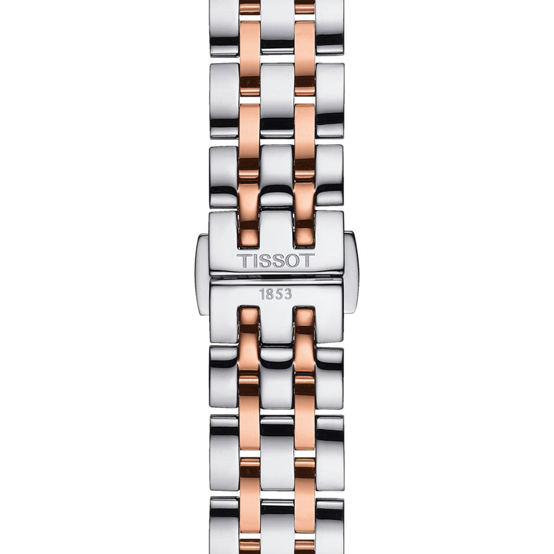 The Tissot Classic Dream Lady Quartz 28mm Watch, adorned with silver and rose gold links, exudes sophistication. The clasp elegantly features the Tissot brand name and the year 1853, making it ideal for those who admire classic timepieces.