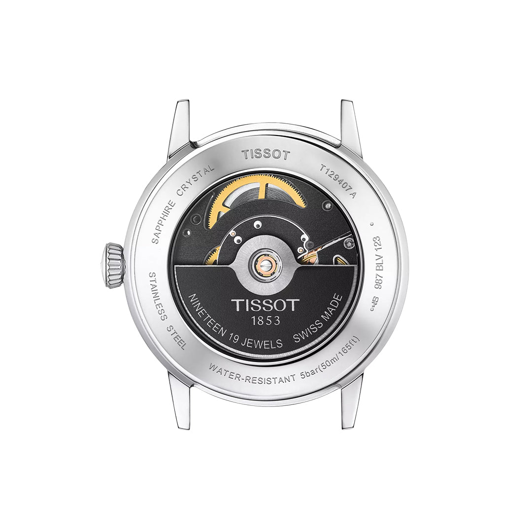 Back view of the Tissot Classic Dream Swissmatic 42mm Watch shows its exposed automatic movement with gold gears, stainless steel case, “TISSOT 1853,” “Nineteen 19 Jewels Swiss Made,” plus diameter, power reserve, and water resistance details.
