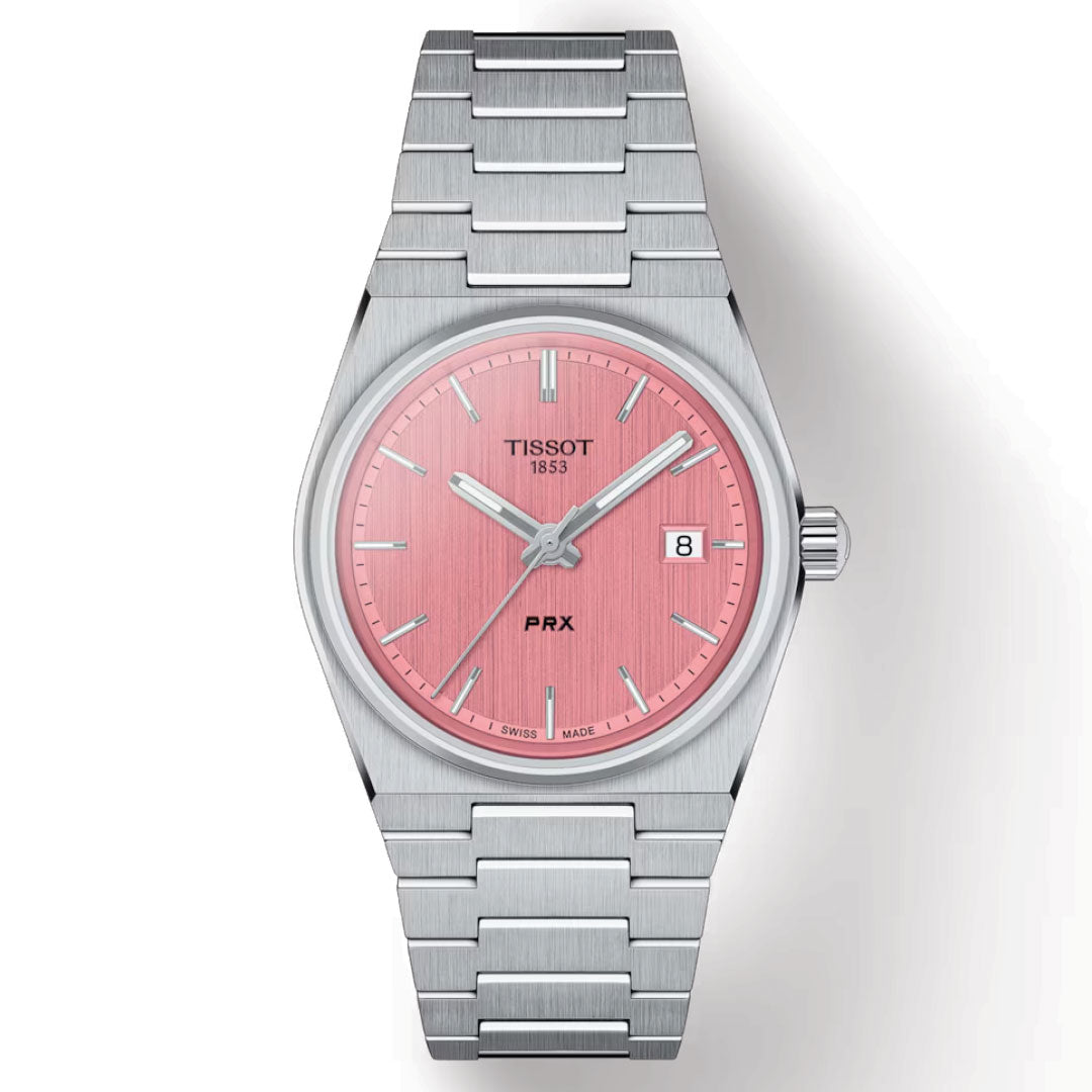 The Tissot PRX Quartz 35mm Watch features a stainless steel band, Swiss Quartz movement, and a pink dial. Its scratch-resistant sapphire crystal displays the Tissot logo, "1853," and "PRX." The date function is conveniently located at the 3 o'clock position, complementing its sleek and modern design.