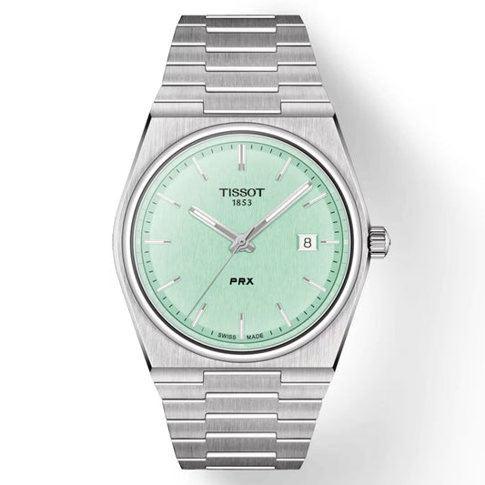 A Tissot PRX Quartz 40mm watch featuring a mint green face, Swiss Quartz movement, and a date display at the 3 o'clock position. The watch includes silver hour markers, a stainless steel bracelet, and a minimalist design enhanced by sapphire crystal for an elegant touch.