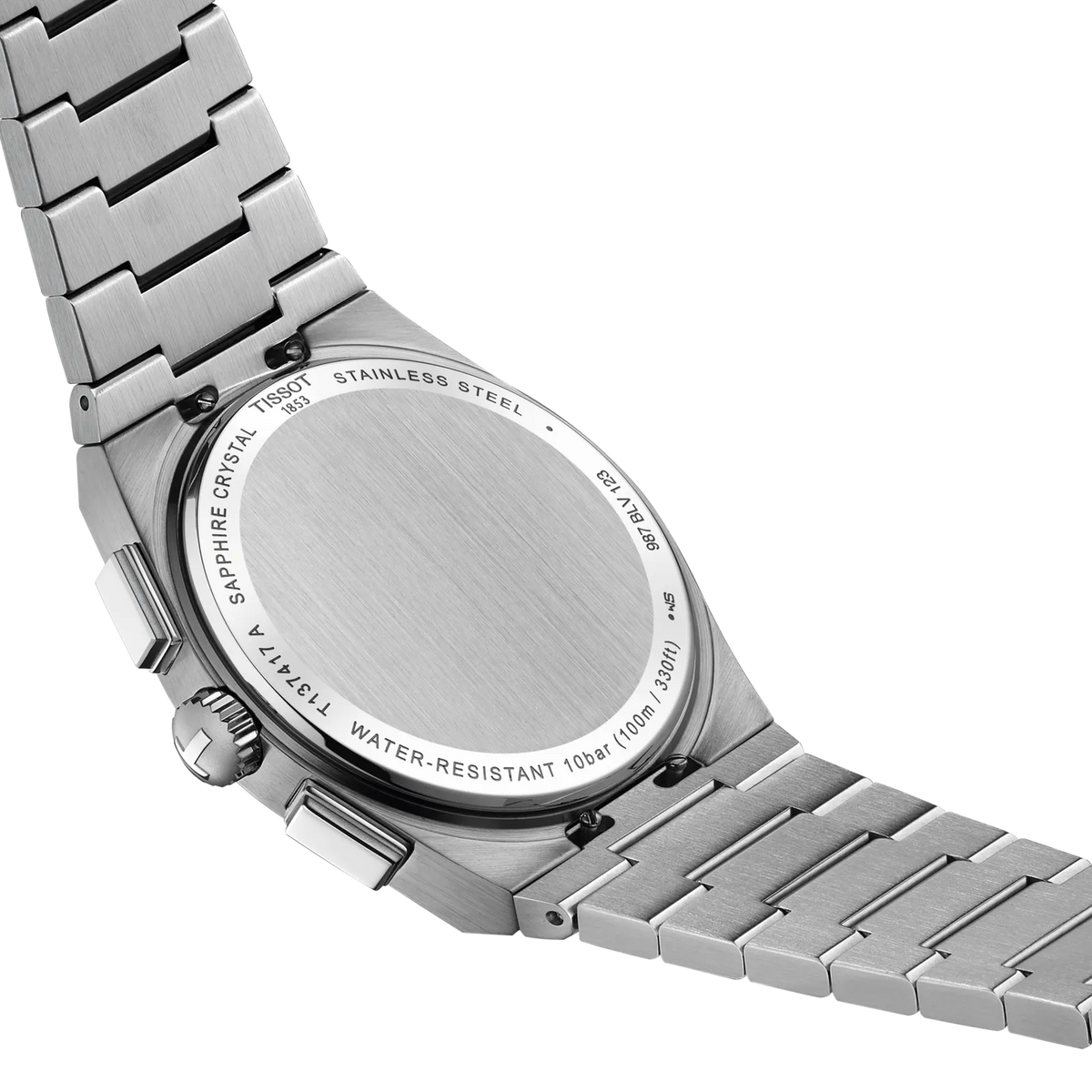 The metallic case back of a Tissot PRX Chronograph Quartz 41mm Watch with a metal link bracelet, showing engraved technical specifications and model details around the circular brushed center.