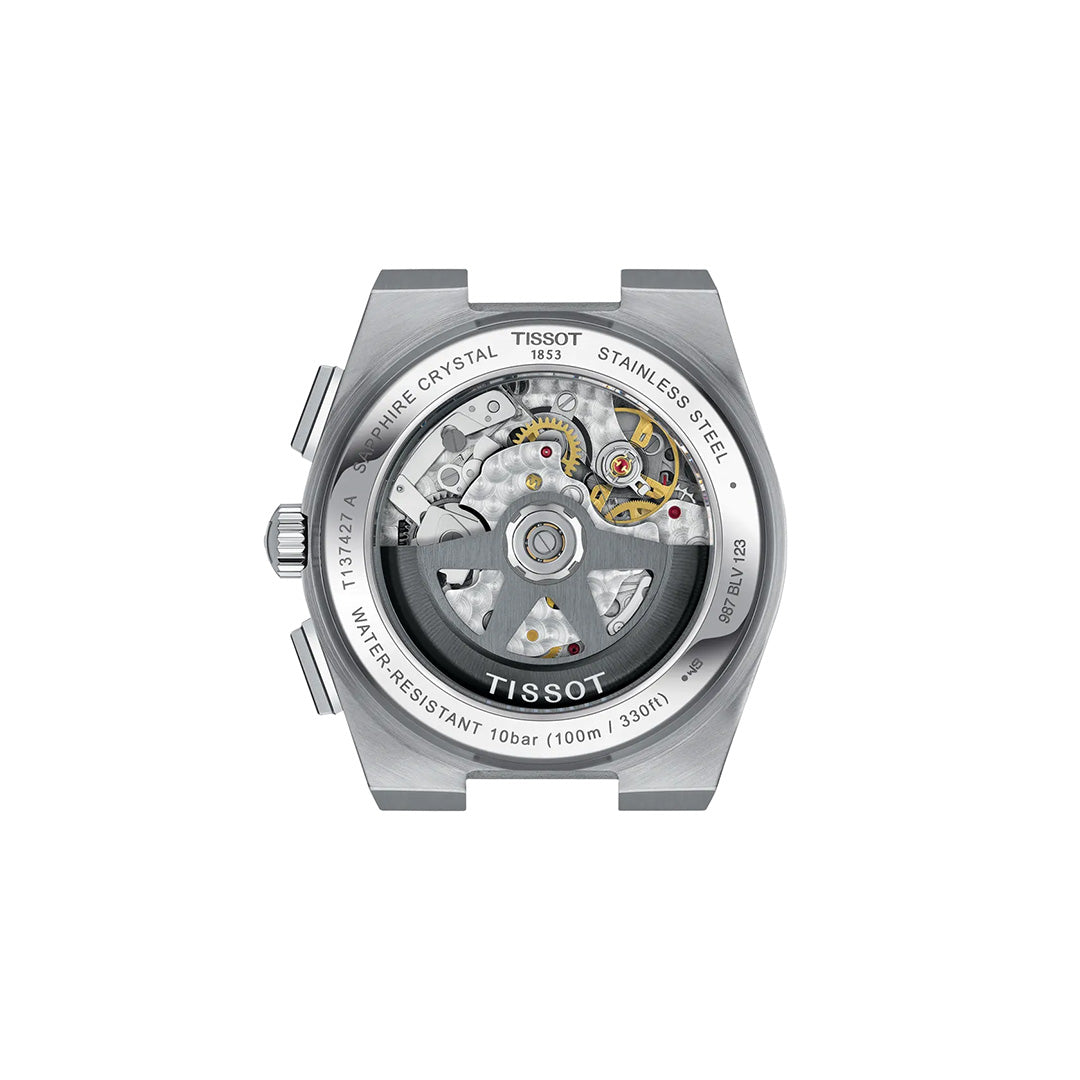 Close-up of the back of a Tissot PRX Automatic Chronograph 42mm Watch, displaying its detailed automatic movement through a transparent case back, with intricate gears and engraved text visible on the rim of the steel case.