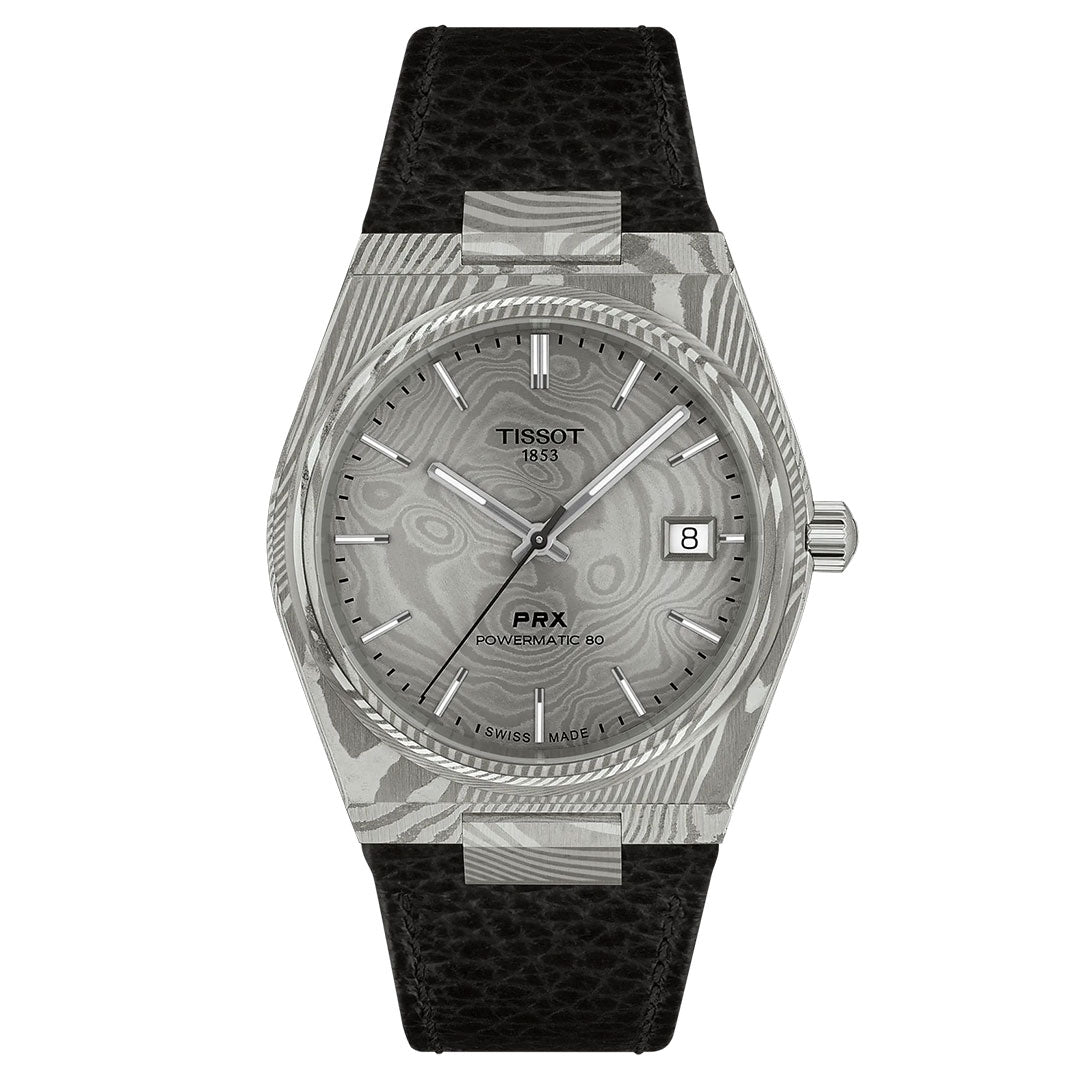 The Tissot PRX Damascus Steel Powermatic 80 Automatic 38mm Watch features a silver patterned dial, silver markers, date at 3 o’clock, black textured leather strap, and a distinctive marbled Damascus stainless-steel case.
