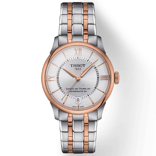 The Tissot Chemin Des Tourelles Powermatic 80 Automatic 34mm Watch features a silver and rose gold two-tone stainless steel bracelet with Swiss automatic movement. Its round face includes rose gold hour markings, Roman numerals at the positions of 12 and 6, and a date window at 6 o'clock. The watch is complemented by a rose gold bezel and a white dial with a textured pattern.